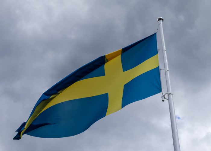 33147268_sweden-flag-at-a-flagpole-moving-slowly-in-the-wind-against-the