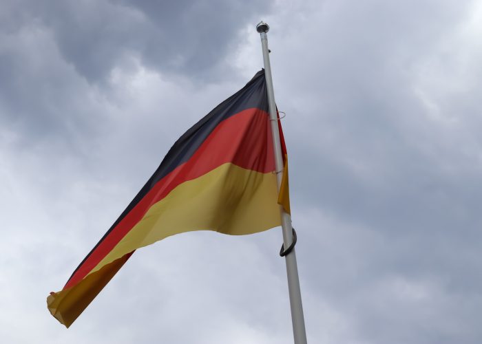 33147266_germany-flag-at-a-flagpole-moving-slowly-in-the-wind-against-the